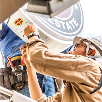 高所作業車を使って看板点検を行う技術スタッフの写真イメージ